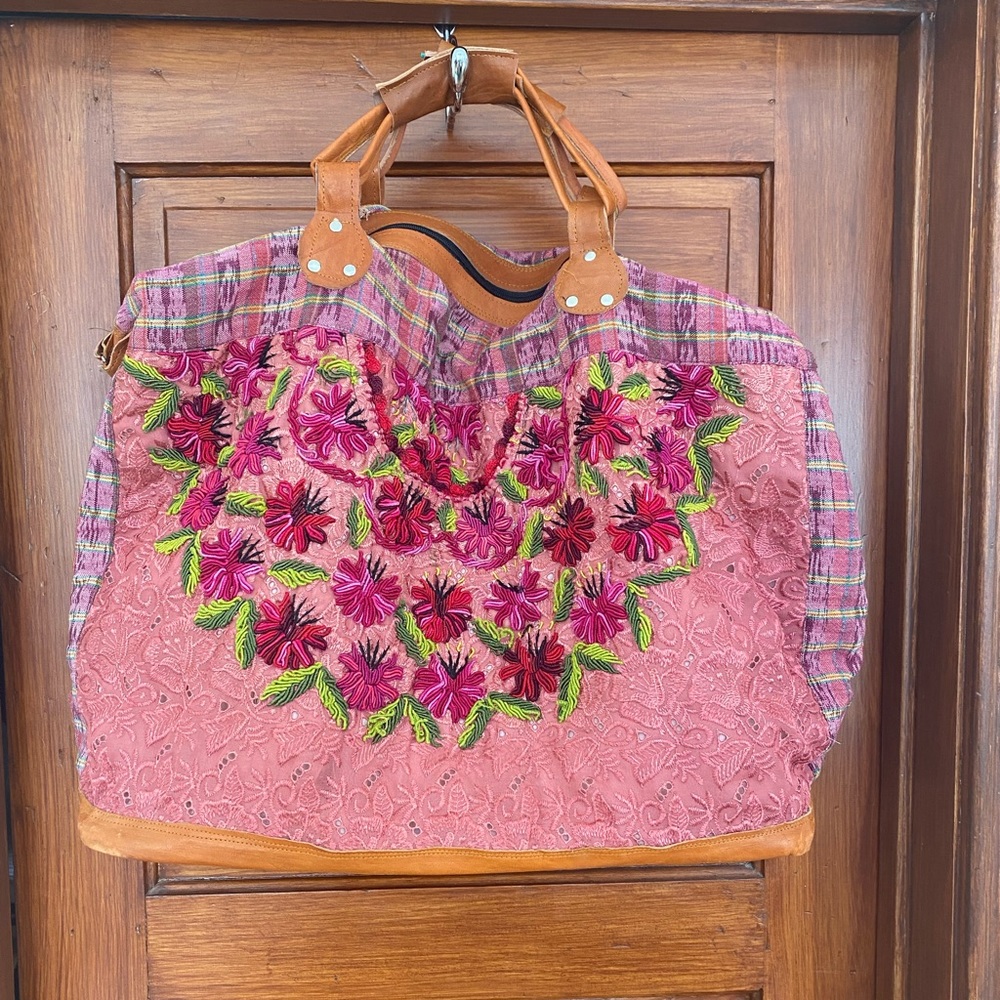 Embroidered weekend bag with shoulder strap.
